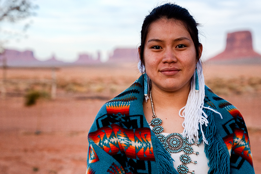 Native American woman on Tribal land stands outside.